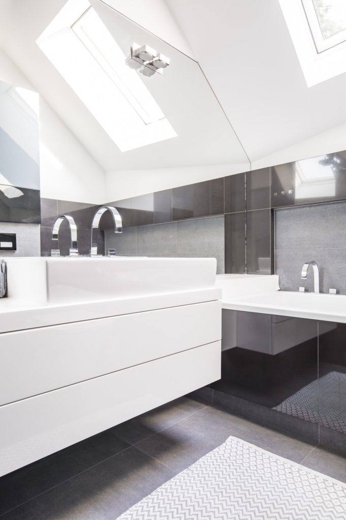 Big mirror by a modern, white washbasin cabinet in a fancy bathr